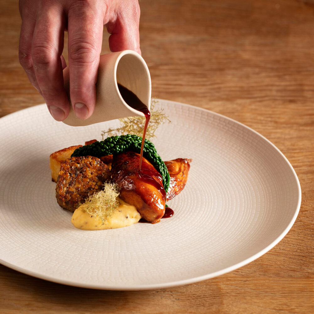 Pouring gravy onto a michelin star dish
